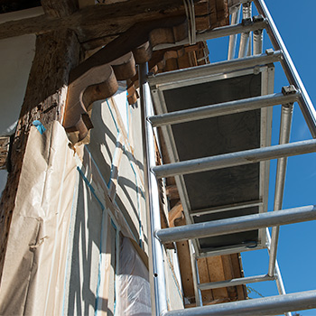 Fachwerkfassade mit abgedeckten Balken  und Baugerüst